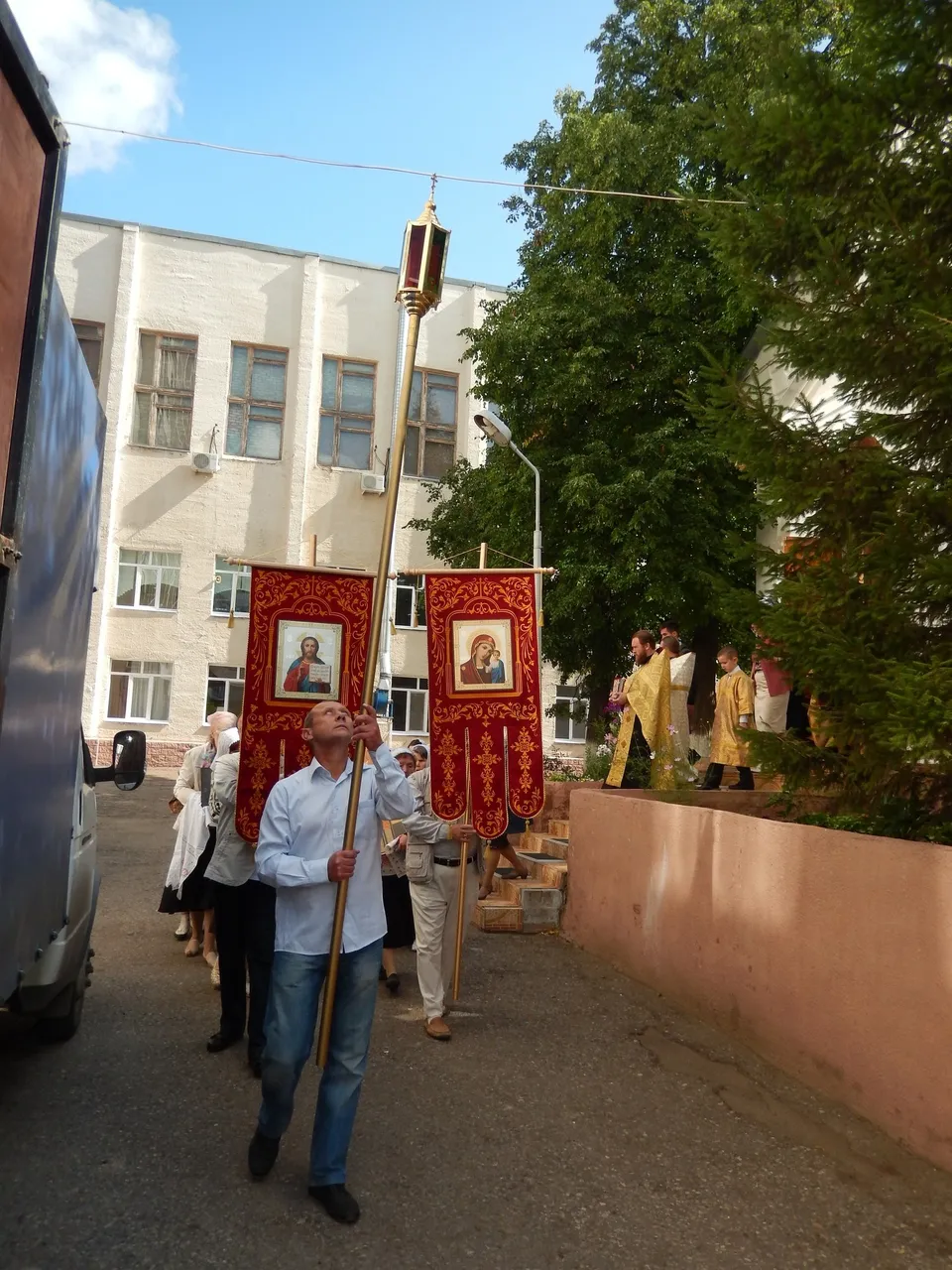 Священник совершает водосвятие у купели с крестом