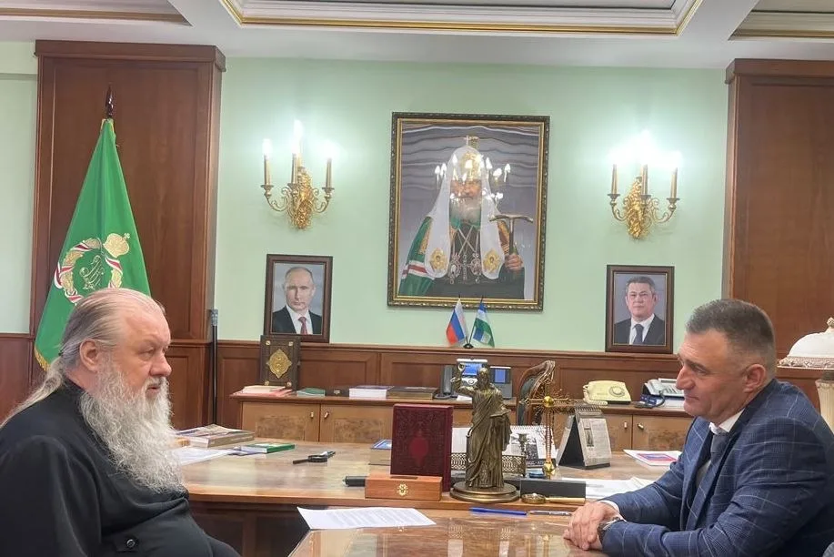 Митрополит и руководитель института беседуют за столом в кабинете